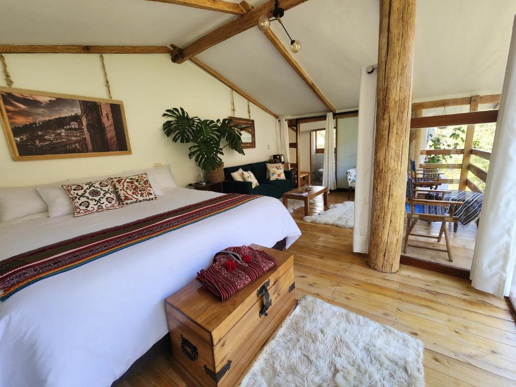 um quarto com uma cama grande e uma sala de estar em Spirit Of The River Lodge em Cusco