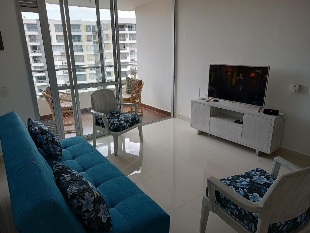 a living room with a blue couch and a tv at Apartamento en Ricaurte Cundinamarca in Ricaurte