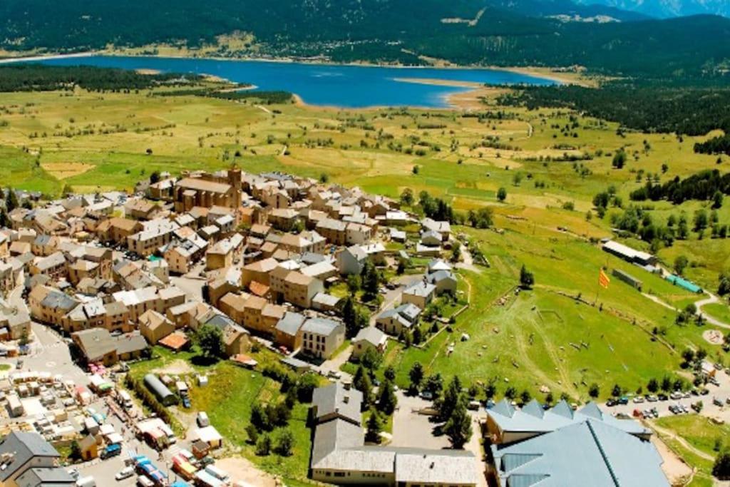 - une vue aérienne sur une petite ville à côté d'un lac dans l'établissement Studio cabine 4 personnes Résidence Le Péric A Terrasse avec vue, aux Angles