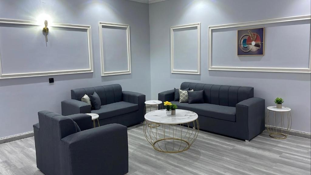 uma sala de espera com dois sofás azuis e uma mesa em غرفة وصالة في أبها em Abha
