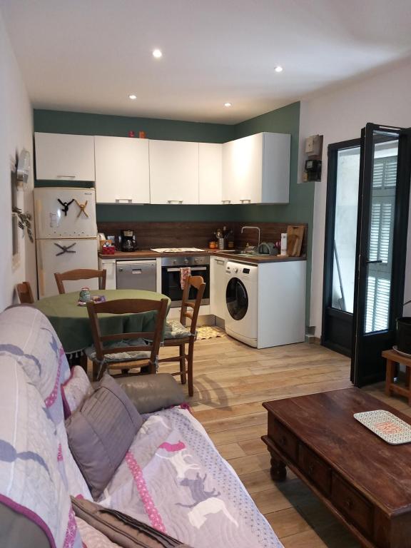 uma sala de estar com um sofá e uma cozinha em Appartement au cœur du Village em Saorge