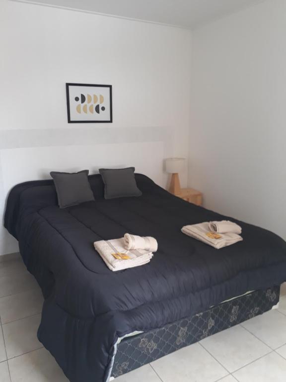 een slaapkamer met een groot bed met twee handdoeken erop bij Departamento Vista Bella, céntrico y cercano a la terminal, Exc ubicación, playa estacionamiento cercana-económica in Villa María