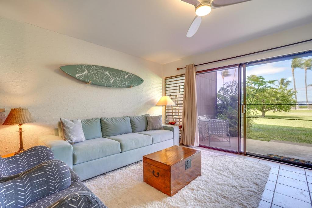 ein Wohnzimmer mit einem Sofa und einem Tisch in der Unterkunft Kaunakakai Home at Molokai Shores with Pool! in Kaunakakai