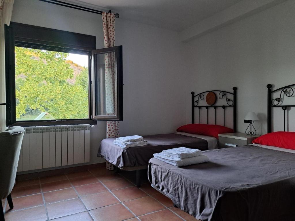 1 dormitorio con 2 camas y ventana grande en Casa rural villa de lupiana, en Lupiana