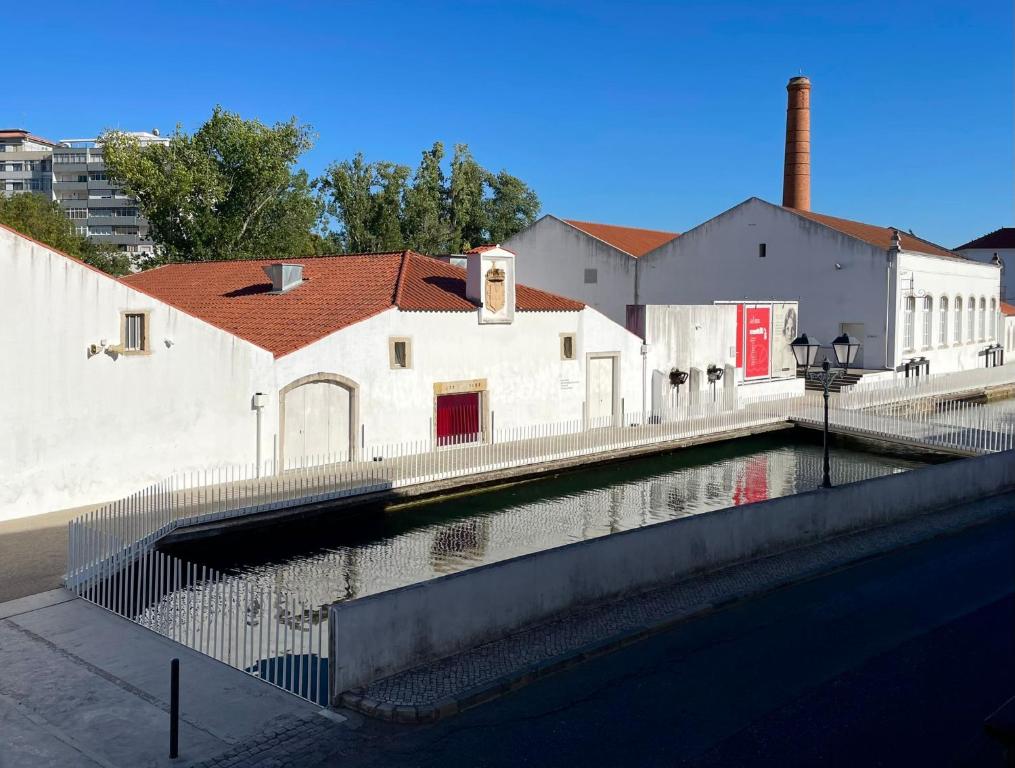 a body of water in front of a white building at Casa da Levada in Tomar
