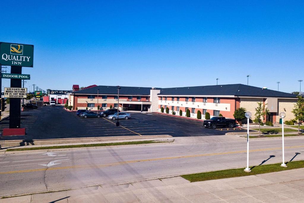 een lege parkeerplaats voor een gebouw bij Quality Inn Stadium Area in Green Bay