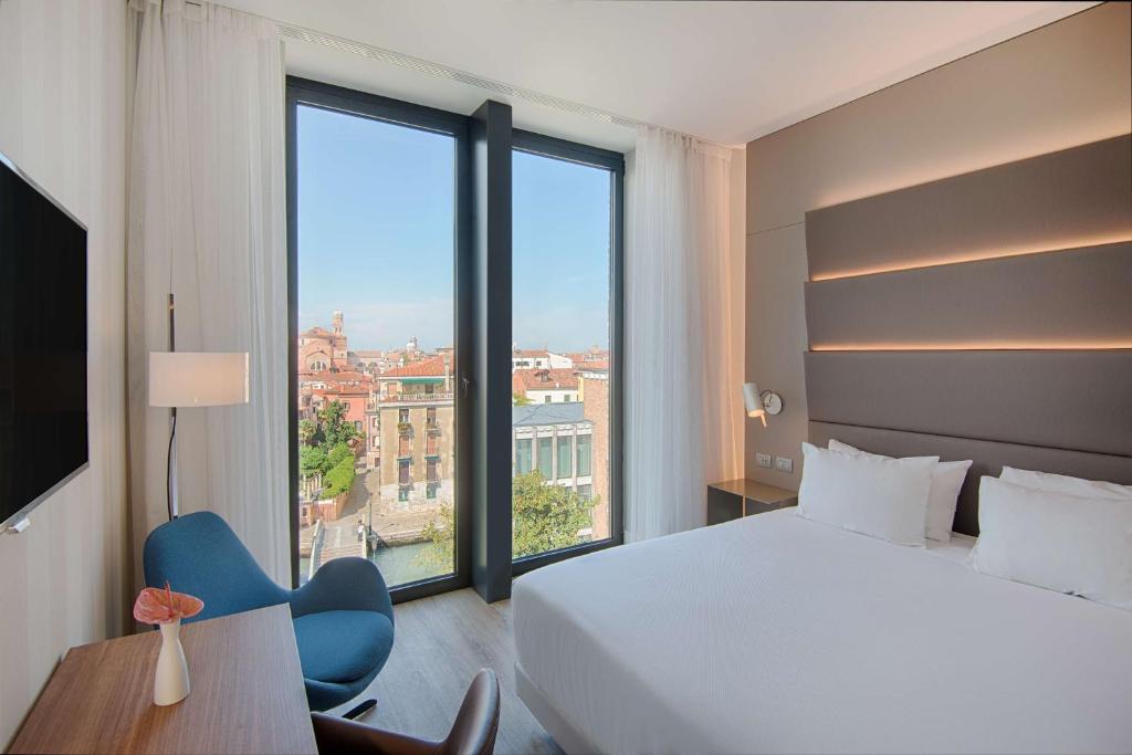 a hotel room with a bed and a large window at Avani Rio Novo Venice Hotel - previously NH Venezia Rio Novo in Venice