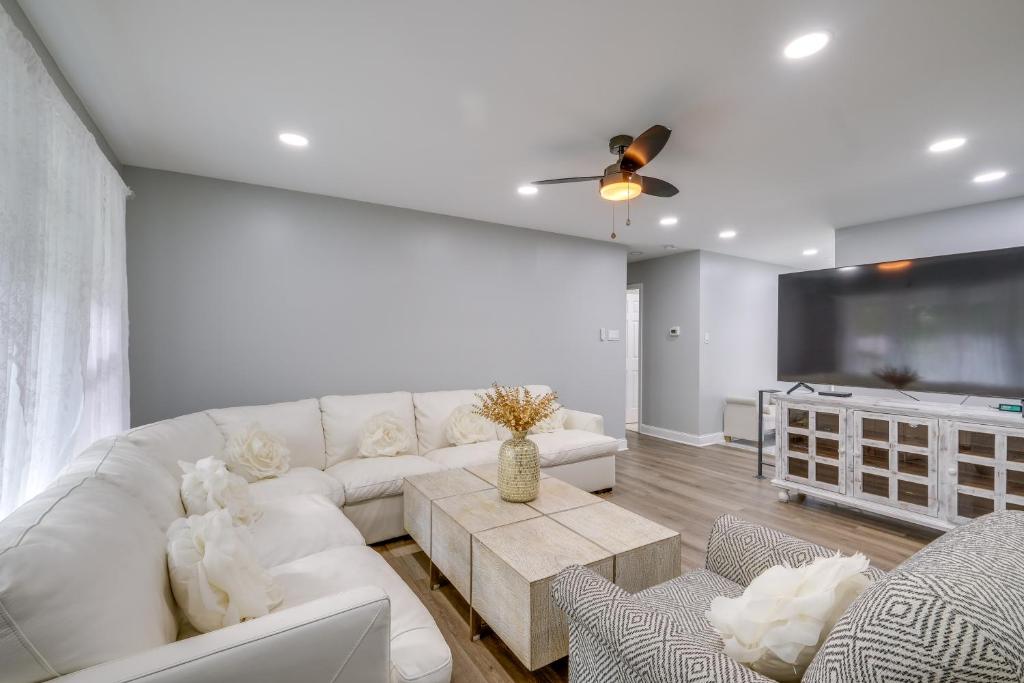 a living room with a white couch and a tv at Fort Washington Home Close to National Harbor in Fort Washington