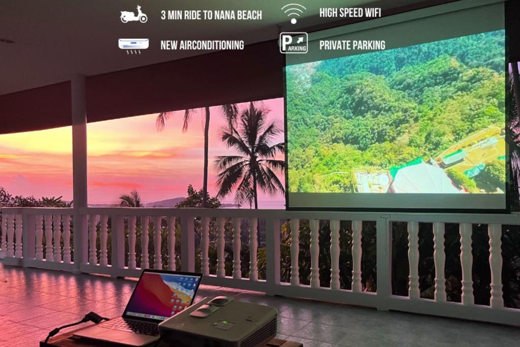 un ordinateur portable assis sur une table devant un écran dans l'établissement Breathtaking Sea View house from your BED - 3 min to BEACH, à Koh Samui 