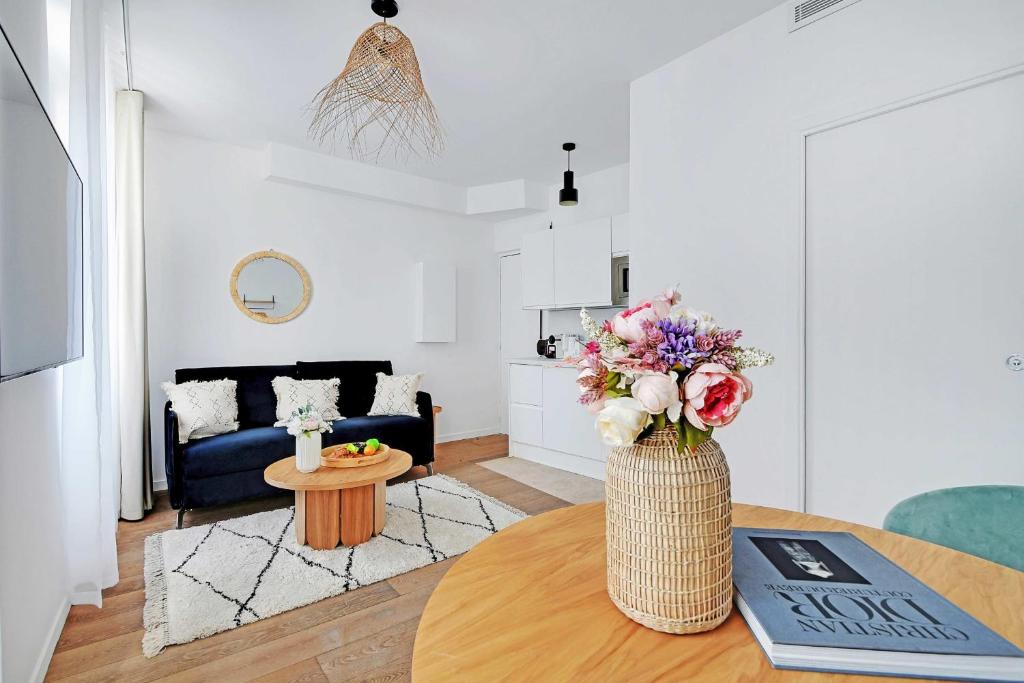 un salon avec un vase de fleurs sur une table dans l'établissement Résidence Sacré Coeur, à Paris