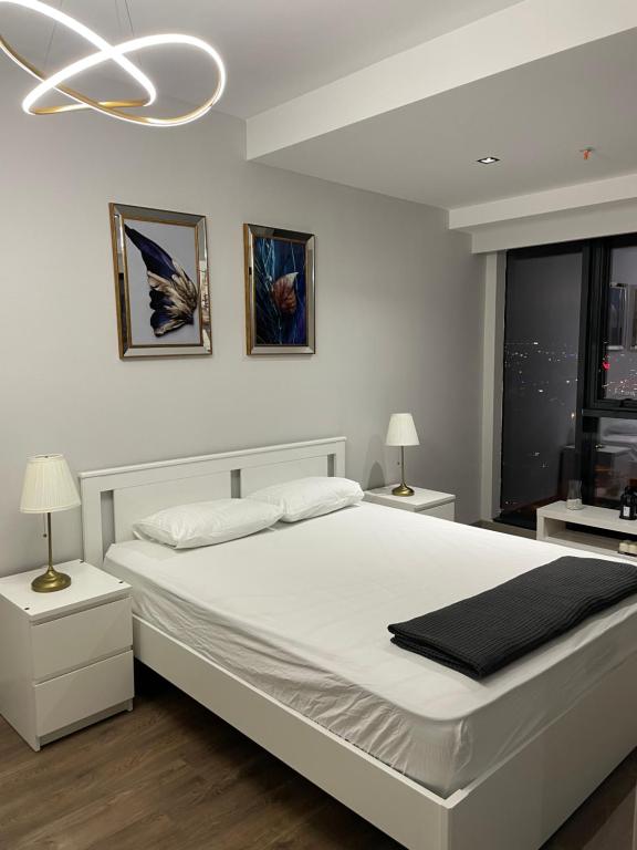 a white bedroom with a large white bed and a chandelier at 2 bedrooms apartment in 5 stars Hotel comfort in Istanbul