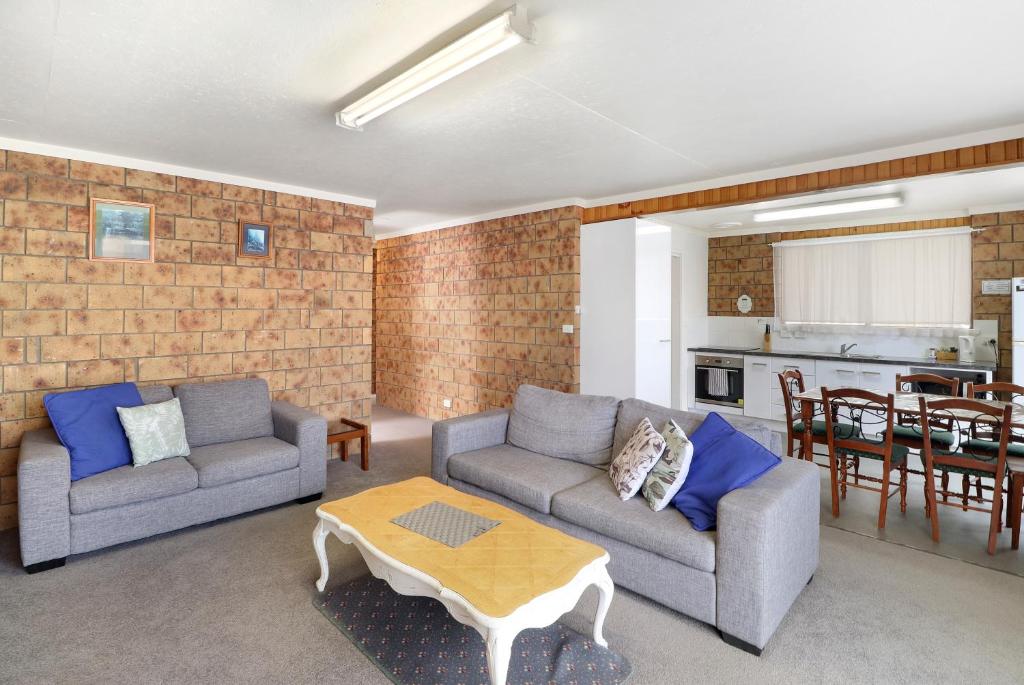 a living room with two couches and a table at Kellraine Holiday Units in St Helens