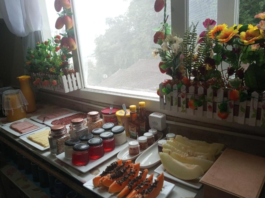 um buffet de alimentos com queijo e outros alimentos em Pousada da Alê em Blumenau