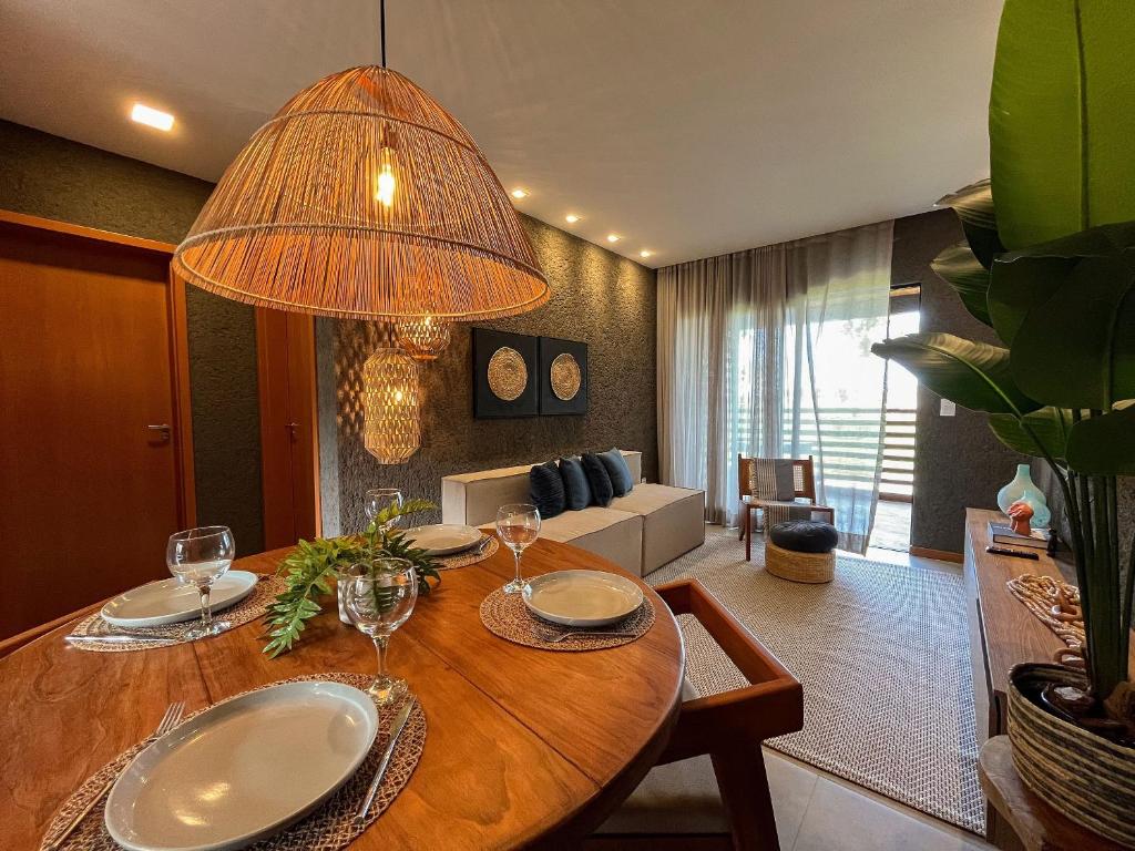 ein Esszimmer mit einem Tisch mit Weingläsern in der Unterkunft Villas Manatee Apartamento G103 Nobile Stays in Tatuamunha