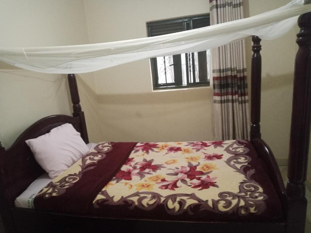 ein Schlafzimmer mit einem Himmelbett mit Blumen darauf in der Unterkunft Perfect Visits Breakfast and Bed 