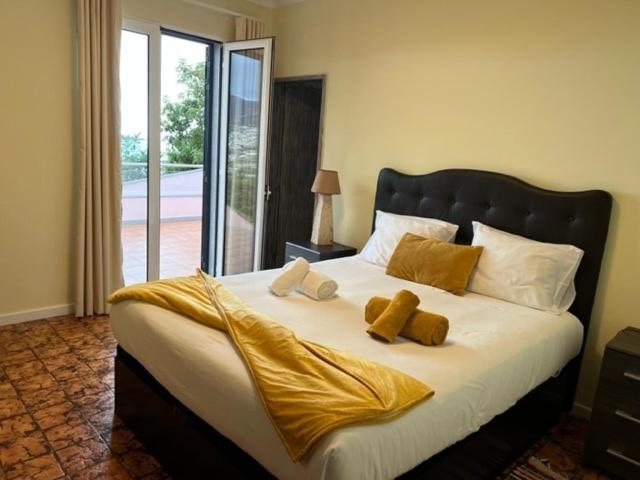 a bedroom with a large bed with yellow sheets at Berço Funchal in Funchal