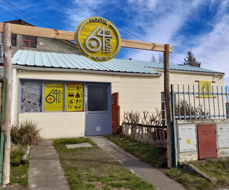 a building with a sign on the side of it at Hostel House 64Bigüa in El Calafate