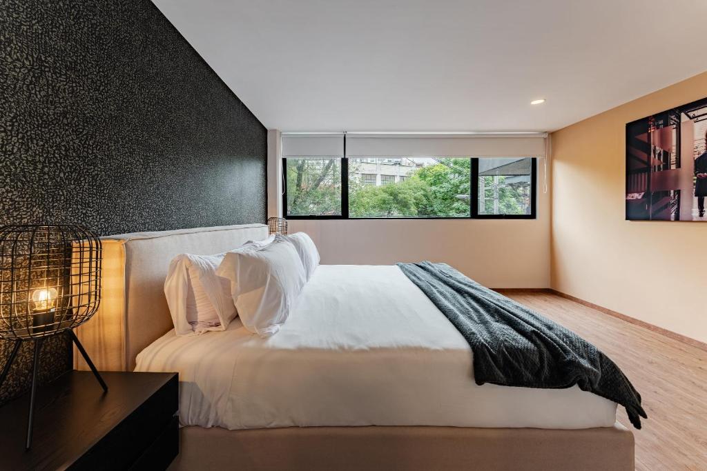 Un dormitorio con una cama grande y una ventana en Signature VH lofts Roma Norte & Reforma, en Ciudad de México