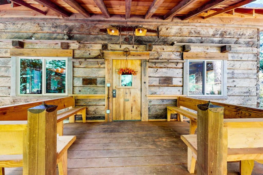 Cabaña de madera con bancos y puerta en The Canopy House, en Clinton