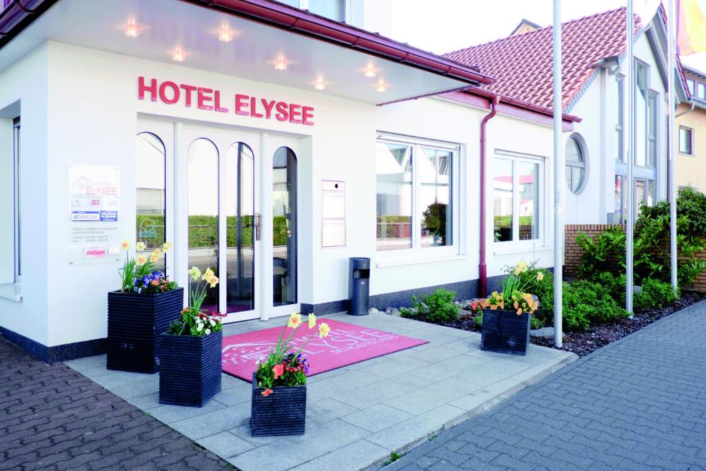 uma fuga de hotel com flores em frente a um edifício em Hotel Elysee em Seligenstadt