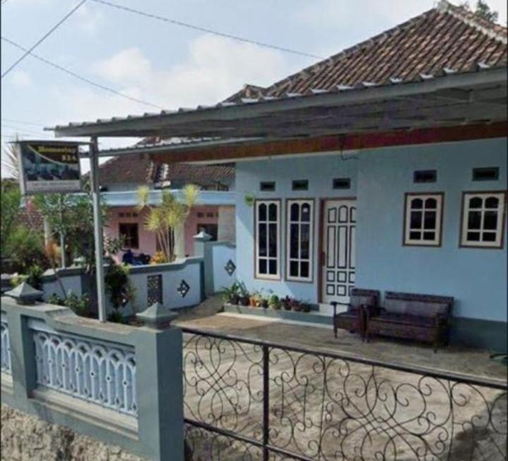 ein kleines weißes Haus mit einem Zaun davor in der Unterkunft Dedwa Homestay syariah in Batu