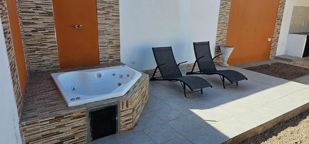 a hot tub sitting on a patio with three chairs at Complejo Llay in La Rioja