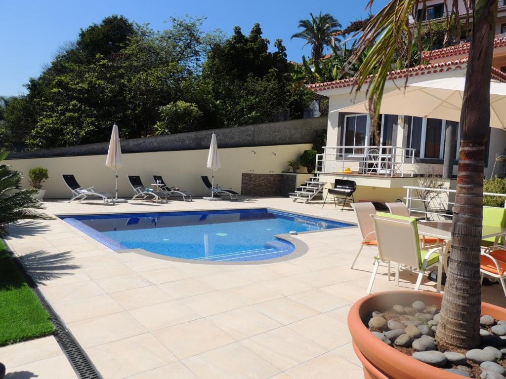 una piscina con sillas y una casa en Studio Flat with Pool, en Funchal