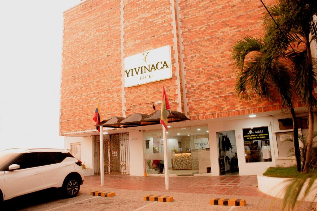 a white car parked in front of a brick building at Hotel Yivinaca in Barranquilla