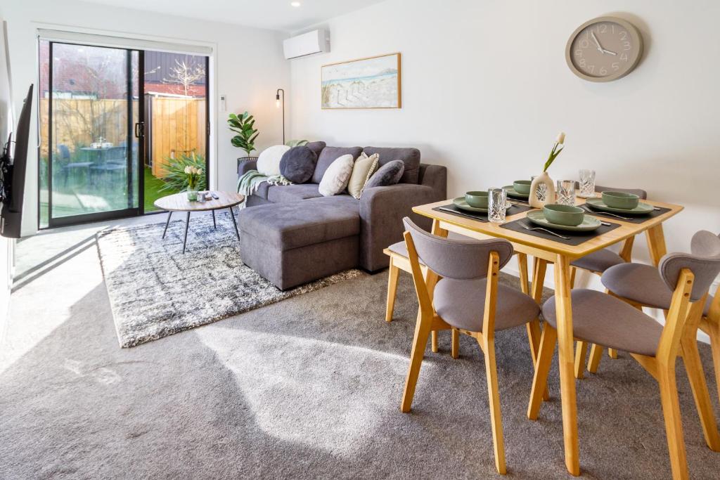 ein Wohnzimmer mit einem Tisch und einem Sofa in der Unterkunft Enchanted Escape 2 bed 2 bath CBD in Christchurch