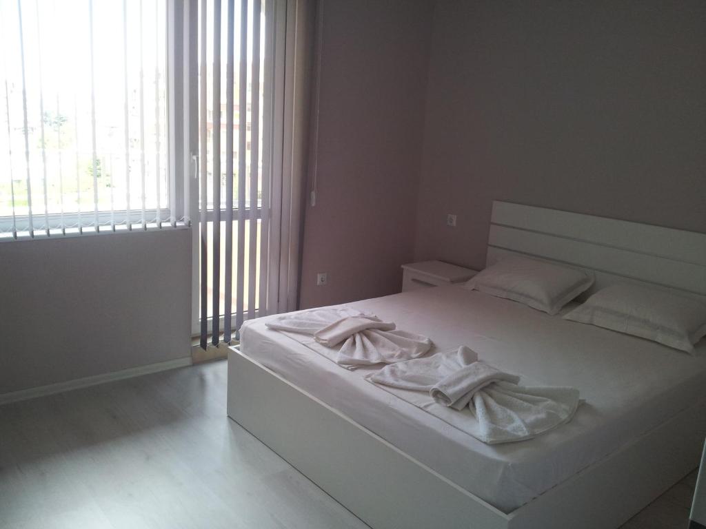 um quarto com uma cama branca e toalhas em Apartment Zlatina em Pomorie