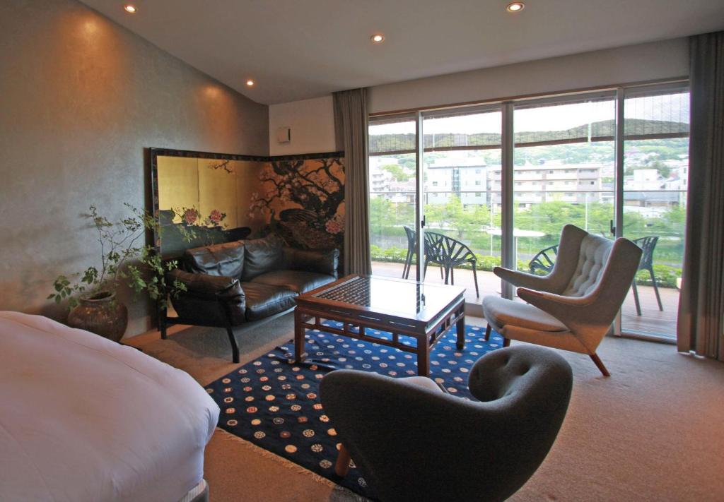 sypialnia z łóżkiem i krzesłami oraz salon w obiekcie Aoi Hotel Kyoto w mieście Kioto