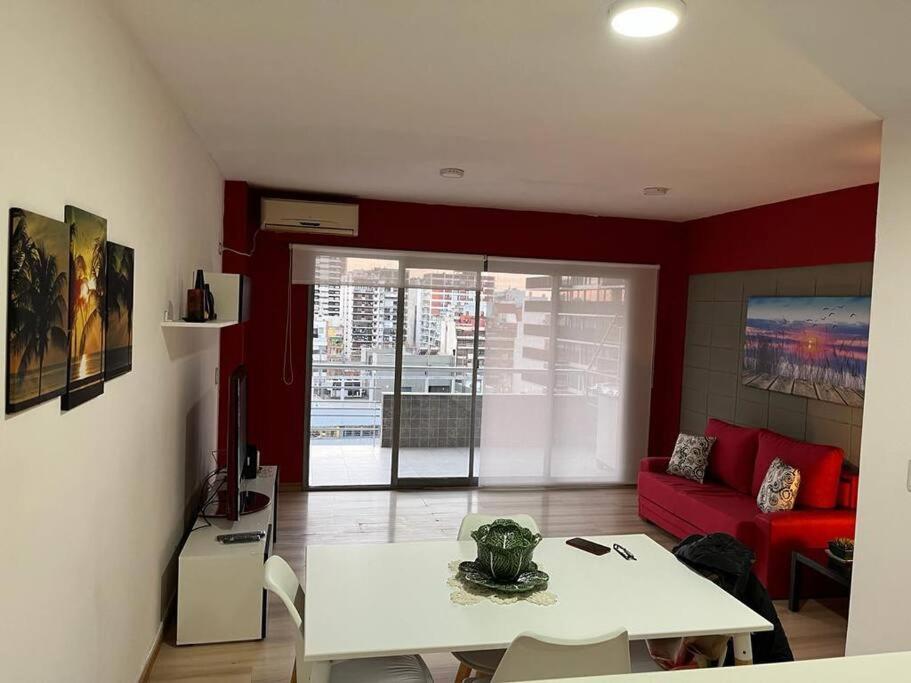 un soggiorno con tavolo bianco e divano rosso di Precioso Departamento en Caballito a Buenos Aires