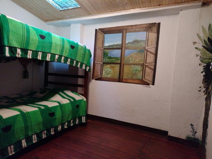 a bedroom with two bunk beds and a window at Hostal Casa del Frailejón - Café in Monguí