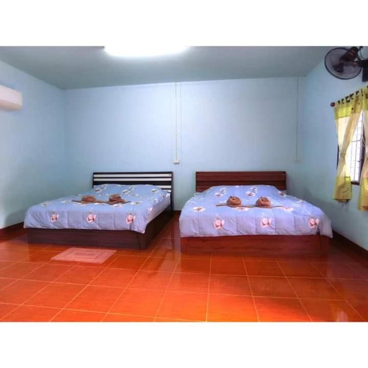 - 2 lits dans une chambre aux murs bleus dans l'établissement Pernjai Homestay 2beds, à Pua