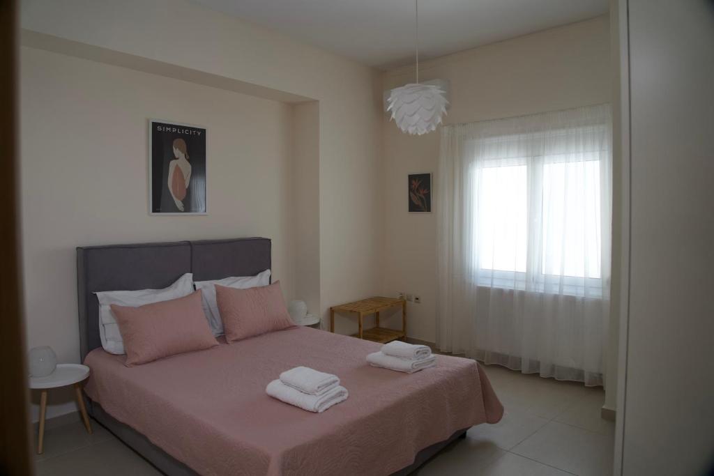 een slaapkamer met een bed met twee handdoeken erop bij Cristina‘s Place in Heraklion