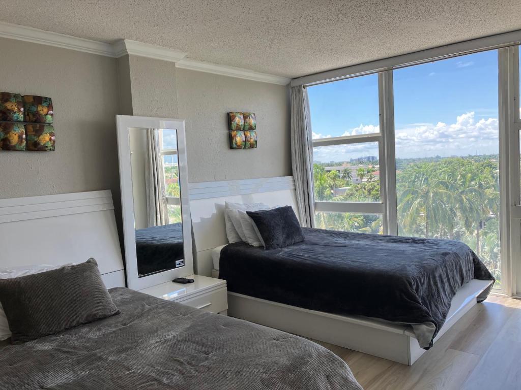 um quarto com 2 camas e uma grande janela em Oceanview on BEACH Fort Lauderdale located in resort, large 2 bedroom corner unit partial ocean view em Fort Lauderdale