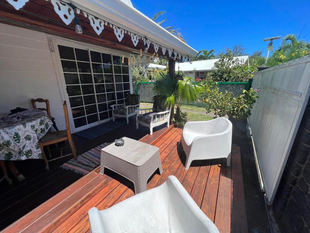 a wooden deck with white chairs and a table at chalet chenal in Hauru