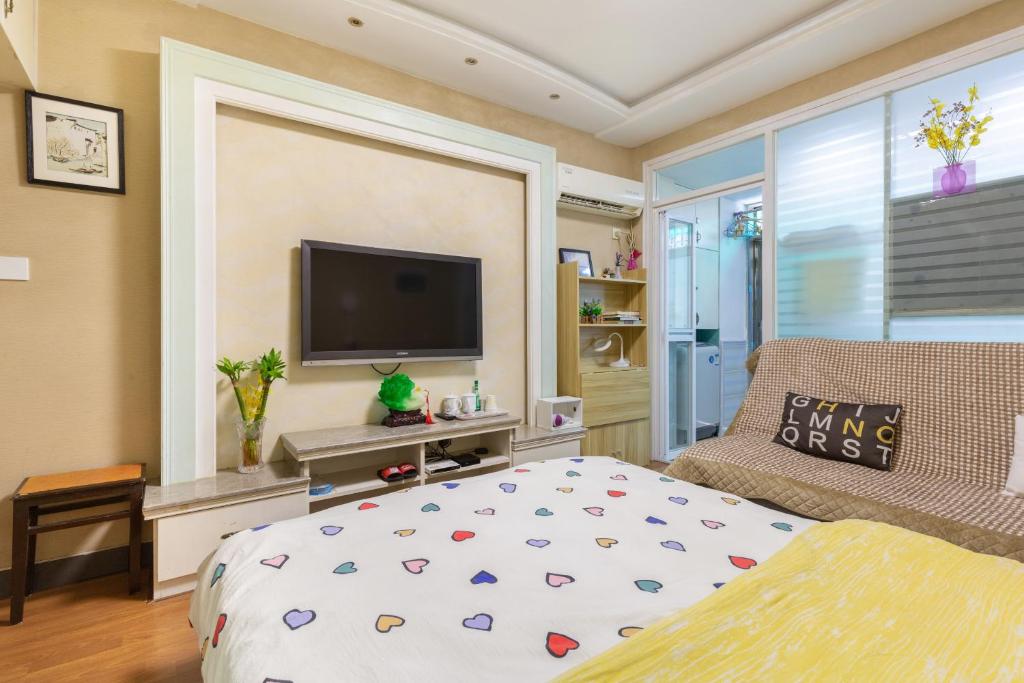 a bedroom with a bed and a flat screen tv at West Lake Hefang Street Metro Exit B&B in Hangzhou