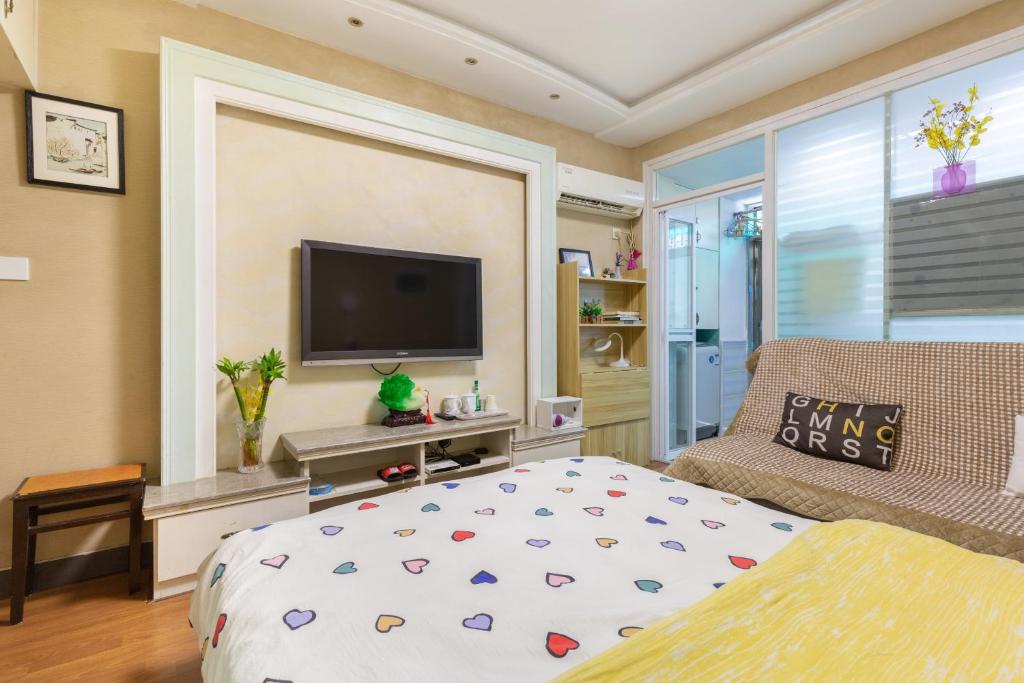 Un dormitorio con una cama y un televisor de pantalla plana. en West Lake Hefang Street Metro Exit B&B, en Hangzhou