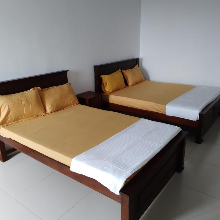 2 letti posti uno accanto all'altro in una stanza di Catamaran6 Guest Inn a Trincomalee