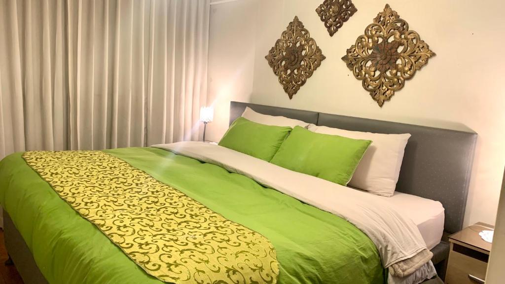 a green and white bed with green sheets and pillows at Cusco Magico 7 - Minidepartamento Las Torres Kayser in Cusco