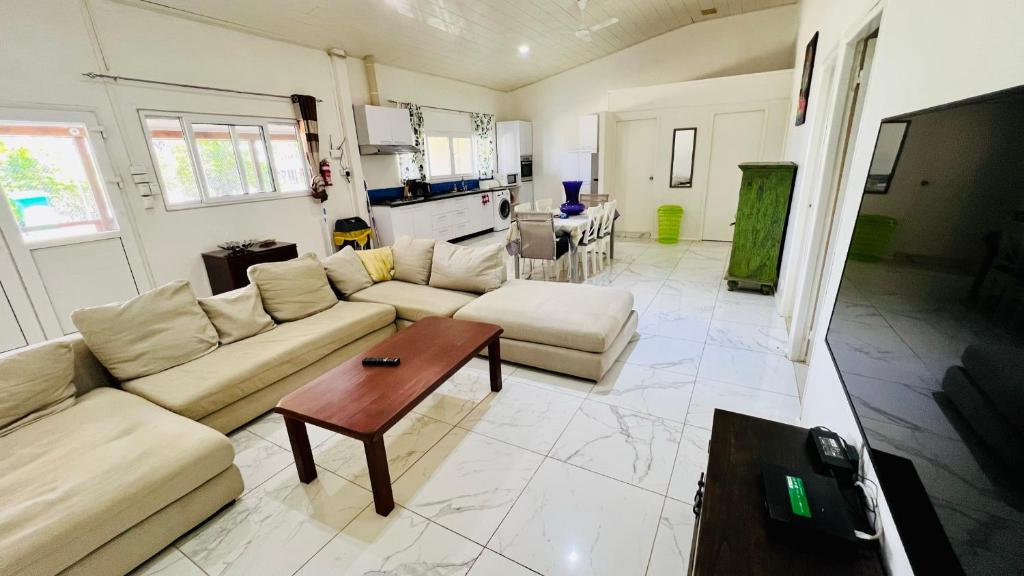 ein Wohnzimmer mit einem Sofa und einem Tisch in der Unterkunft Homely 3 bedroom apartment perfect for your dream getaway! in Port Vila