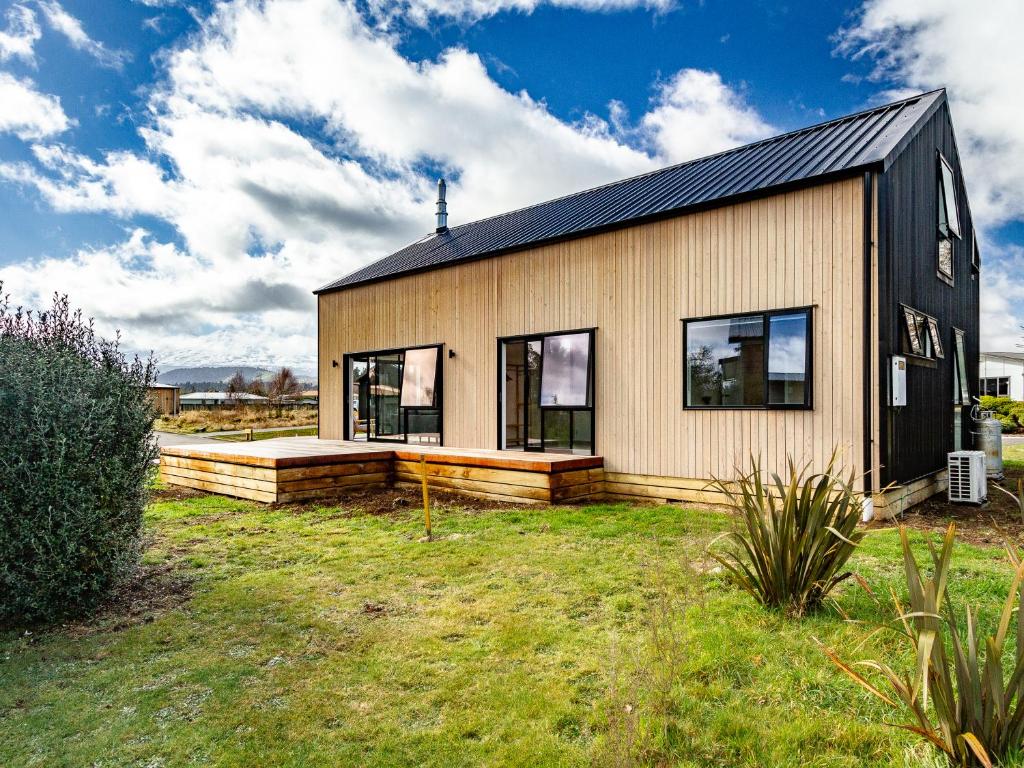 a small house with a black roof and windows at Viewtopia - Ohakune Holiday Home in Ohakune