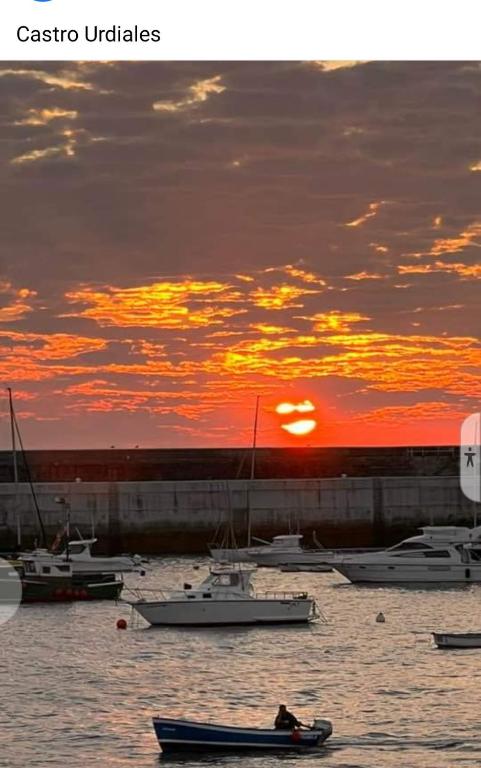 a group of boats in the water at sunset at Castro Urdiales in Castro-Urdiales