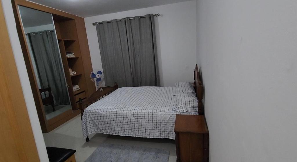 a small bedroom with a bed and a mirror at Nha Maria Apartament in Praia