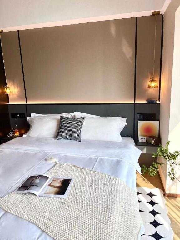 a bedroom with a white bed with a large headboard at Manriver Executive Apartments in Guangzhou