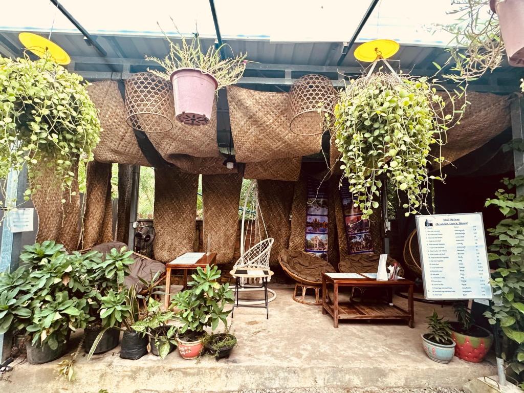 a patio with potted plants and tables and chairs at Angkor Piseth Homestay in Siem Reap