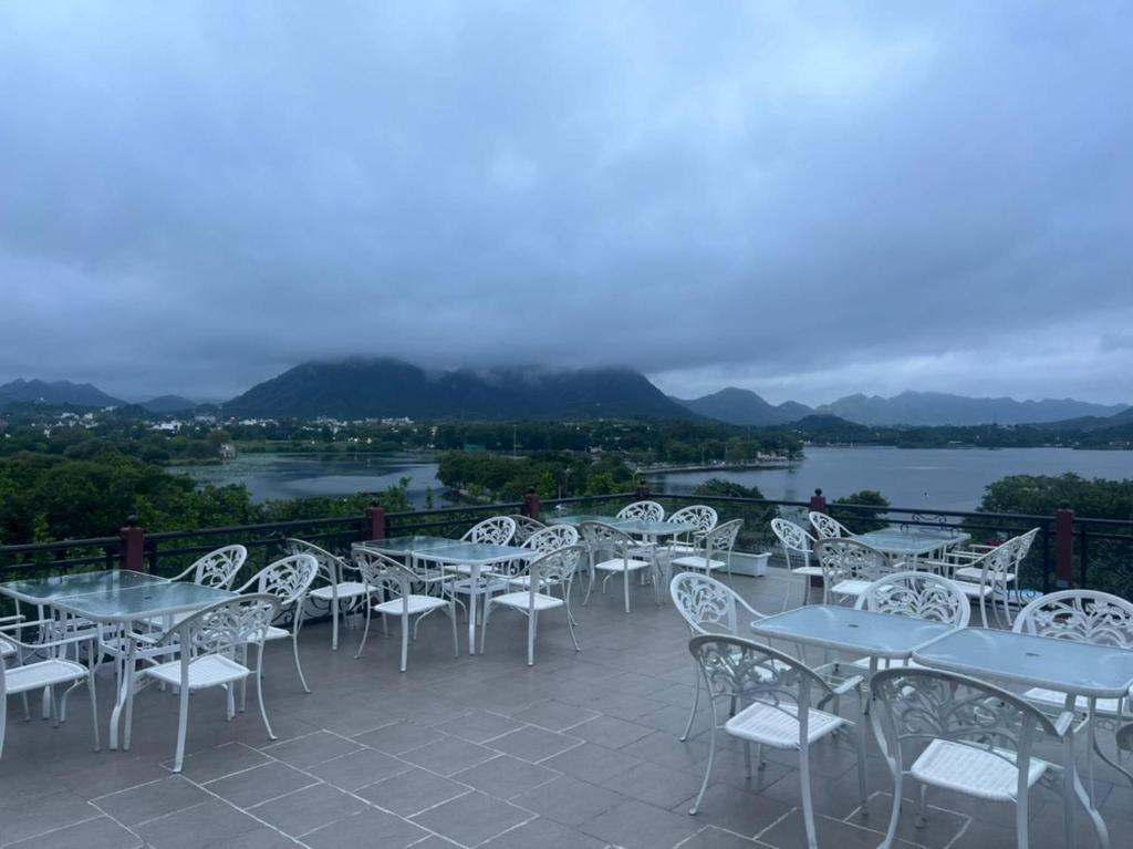 a row of tables and chairs on a patio with a view at Inder Prakash - Best Lake View Hotel in Udaipur in Udaipur