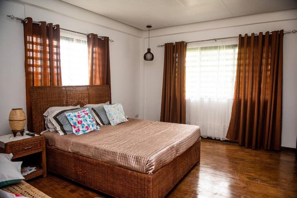 een slaapkamer met een groot bed met kussens erop bij G Apartment - Home in Kabankalan City in Kabankalan