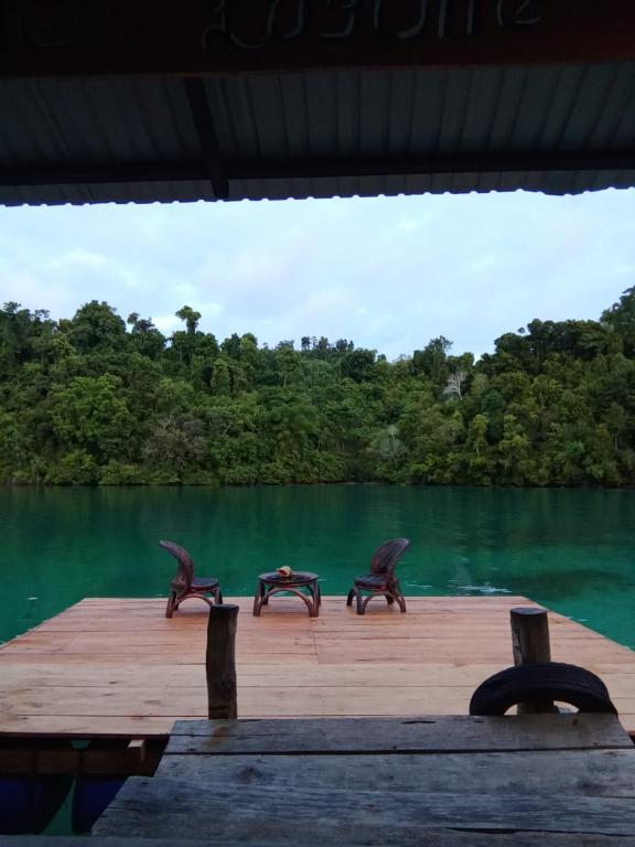 two animal statues sitting on a dock near a body of water at Lestari Cottages in Kododa